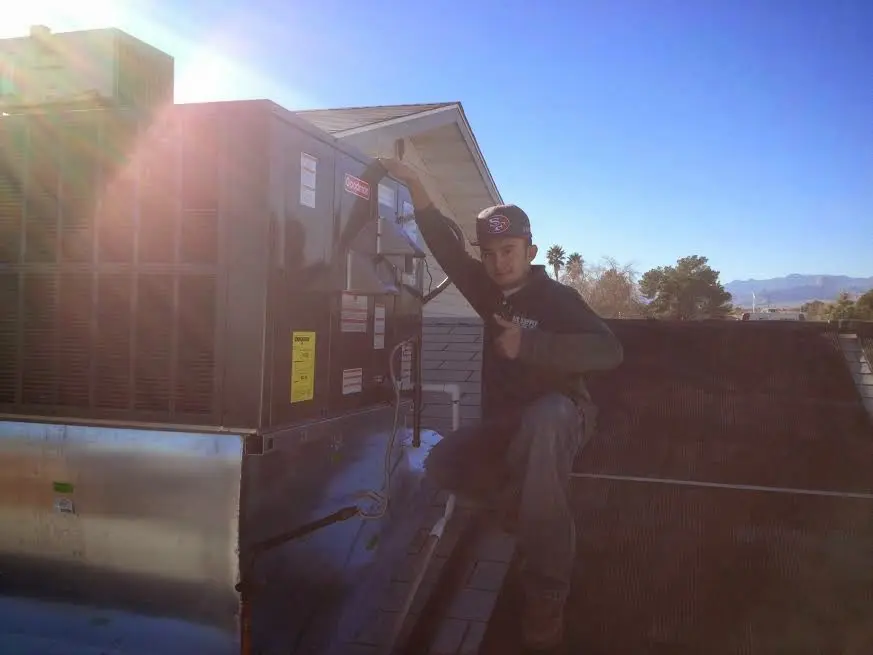 HVAC technician performing AC Tune-Up on a rooftop unit in Swampscott